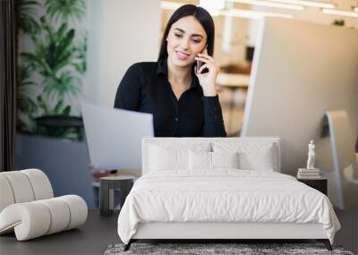 Business, communication and people concept. Happy businesswoman with laptop computer and papers calling on desk phone at office Wall mural